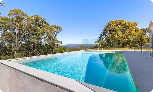 Modern rectangular swimming pool with clear blue water and surrounding deck area.