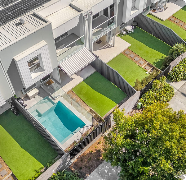 Modern backyard with concrete plunge pool and landscaped garden.